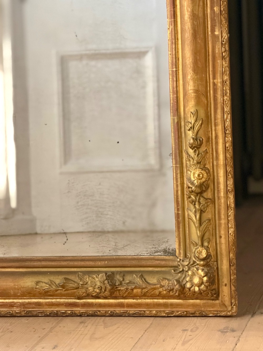 A large 19th-century French Louis Philippe mirror featuring a gilded wood frame with rounded top corners and foxed mercury glass. View VI