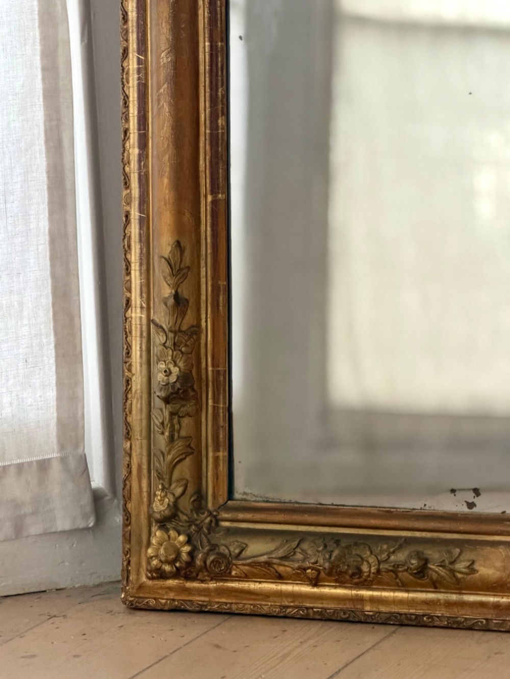 A large 19th-century French Louis Philippe mirror featuring a gilded wood frame with rounded top corners and foxed mercury glass. View VII