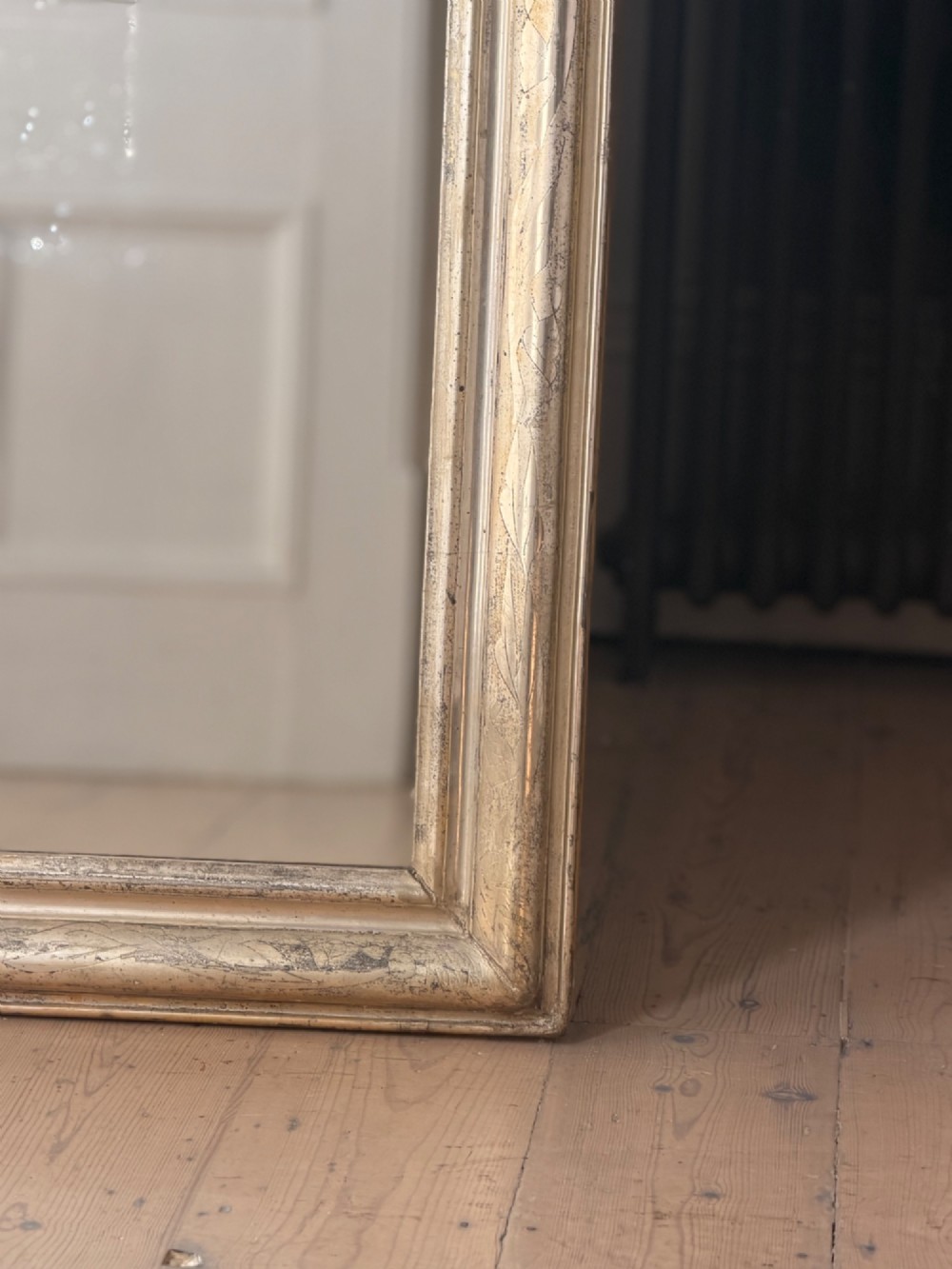 A tall rectangular antique French mirror featuring rounded top corners and a simple silver gilt frame. View II