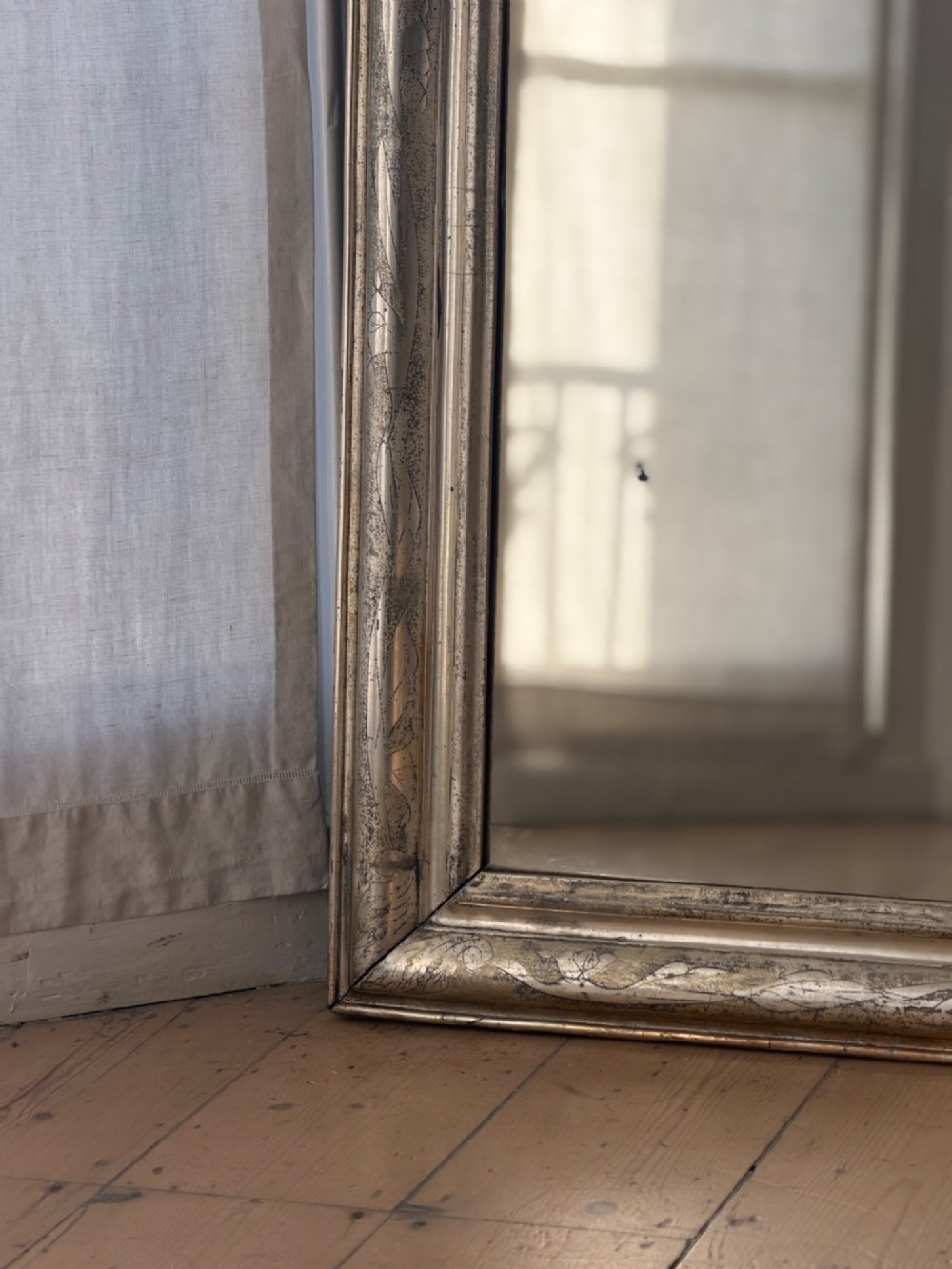 A tall rectangular antique French mirror featuring rounded top corners and a simple silver gilt frame. View IV