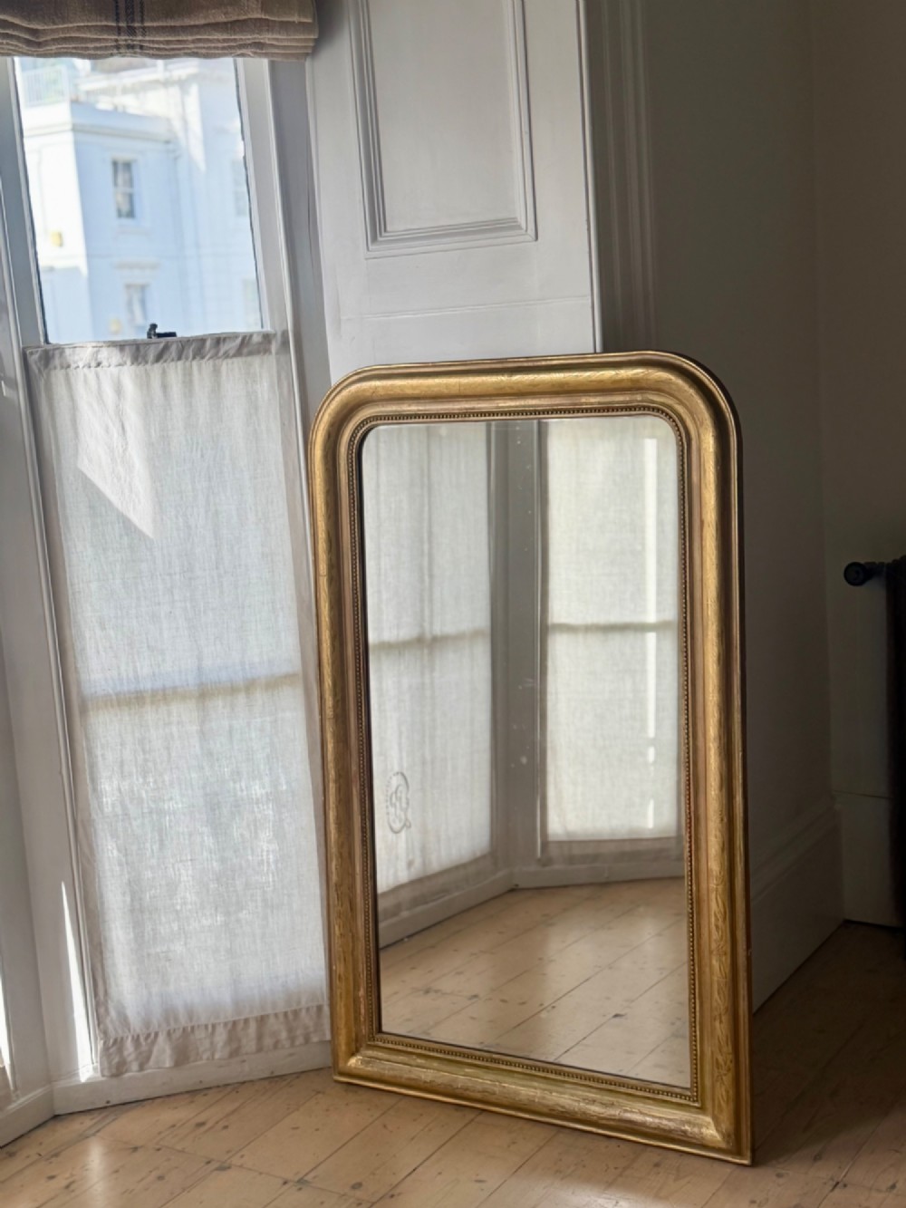 A mid-19th-century French Louis Philippe mirror featuring a gilded frame with rounded upper corners and subtle beaded detailing. View II