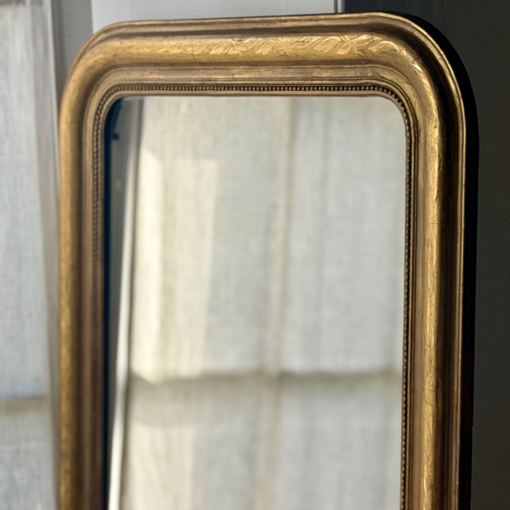A mid-19th-century French Louis Philippe mirror featuring a gilded frame with rounded upper corners and subtle beaded detailing. View V