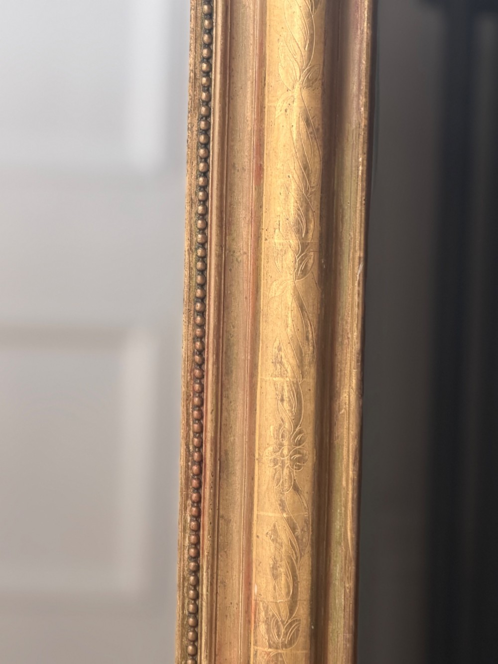 A mid-19th-century French Louis Philippe mirror featuring a gilded frame with rounded upper corners and subtle beaded detailing. View VII