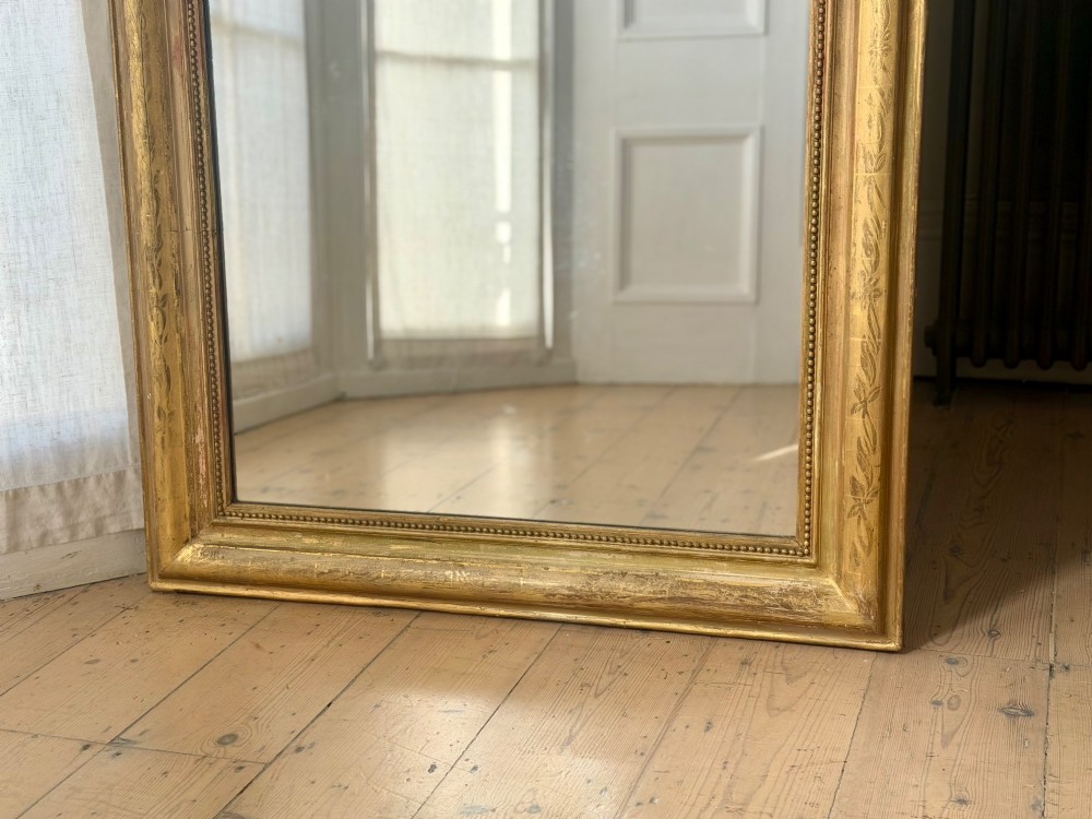 A mid-19th-century French Louis Philippe mirror featuring a gilded frame with rounded upper corners and subtle beaded detailing. View VIII