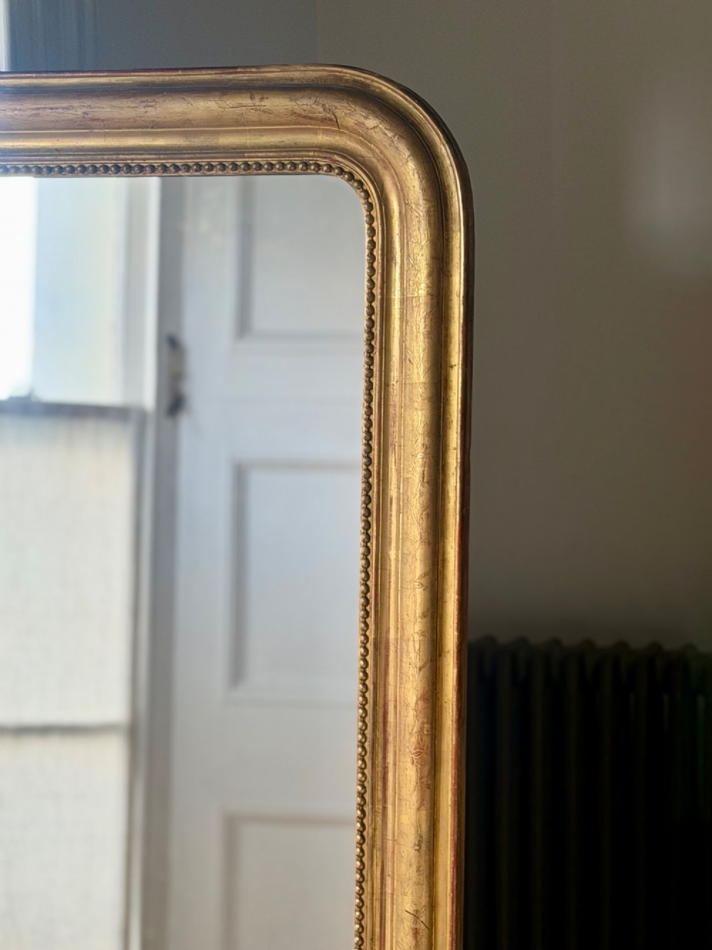 Large rectangular French Louis Philippe mirror featuring rounded upper corners, a beaded inner border, and a gilded finish. View III