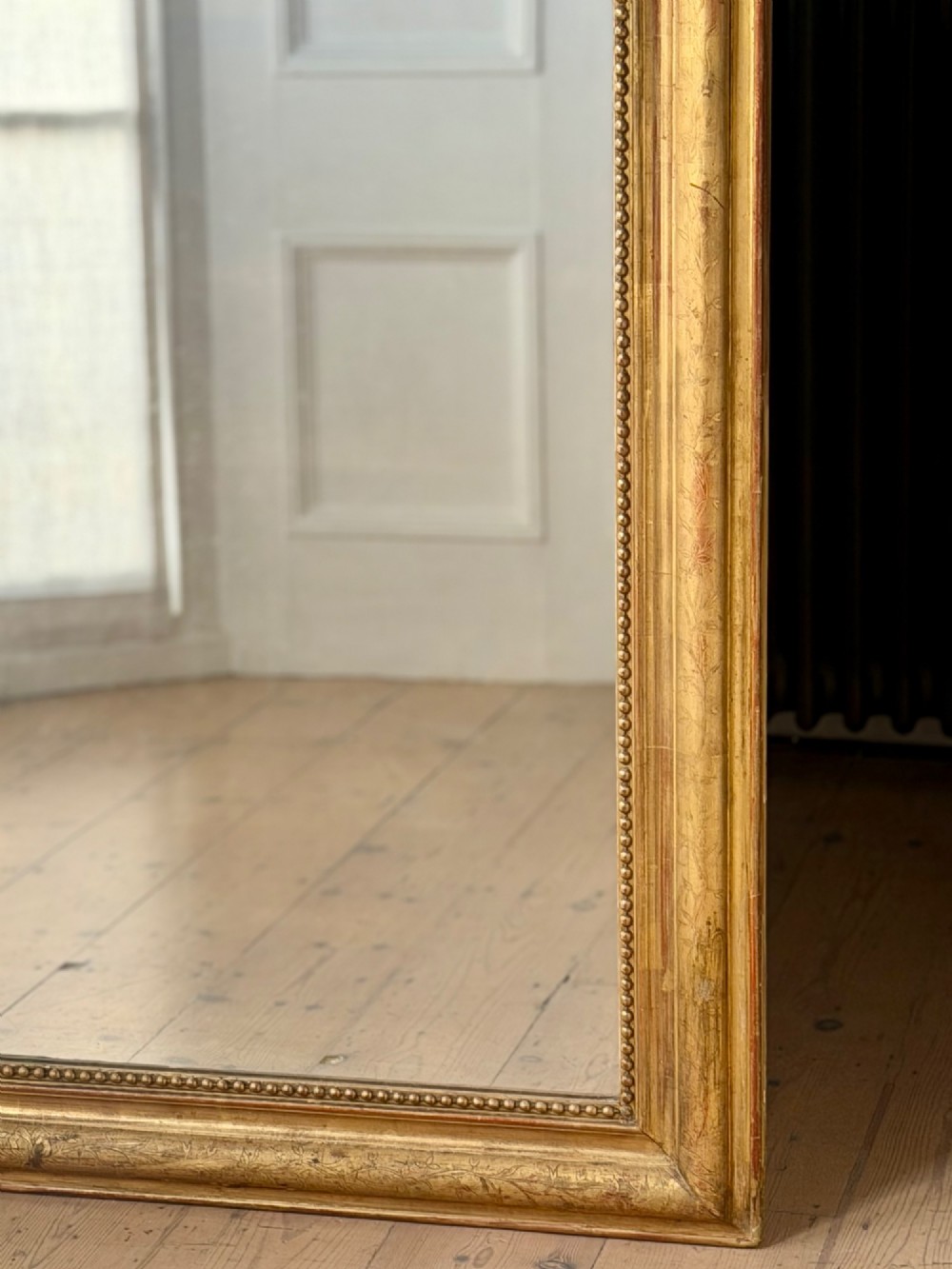 Large rectangular French Louis Philippe mirror featuring rounded upper corners, a beaded inner border, and a gilded finish. View IV