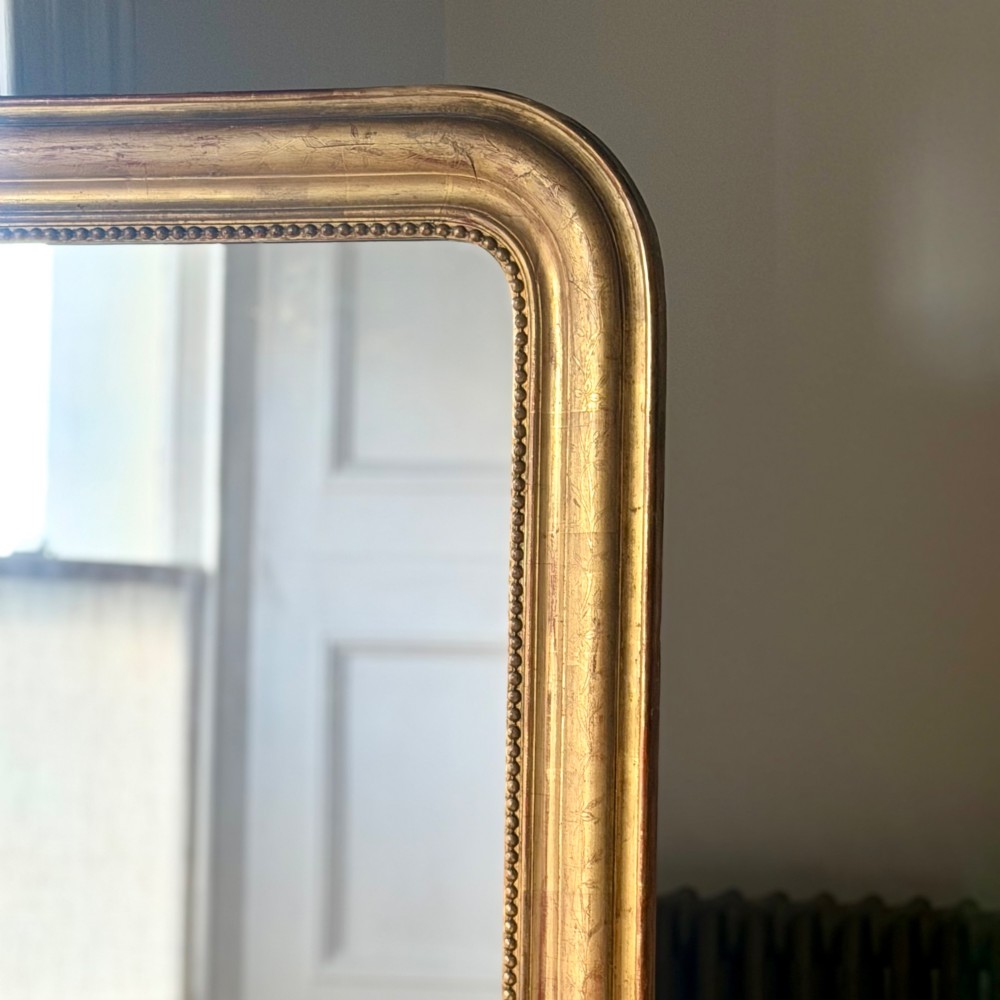 Large rectangular French Louis Philippe mirror featuring rounded upper corners, a beaded inner border, and a gilded finish. View IX