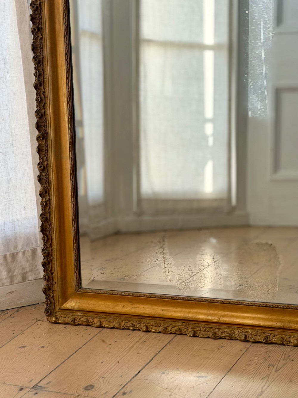 A large French Louis XV style giltwood mirror featuring an arched top crest with carved scrollwork and a bevelled mirror plate. View X