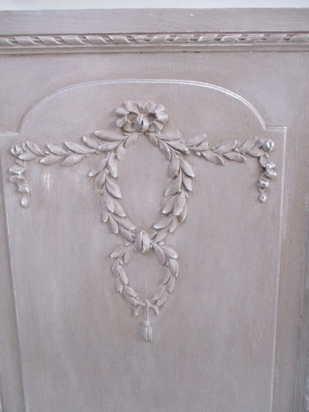 A pair of grey painted wooden cabinet doors decorated with hand-carved laurel wreaths and ribbon swags. View IV