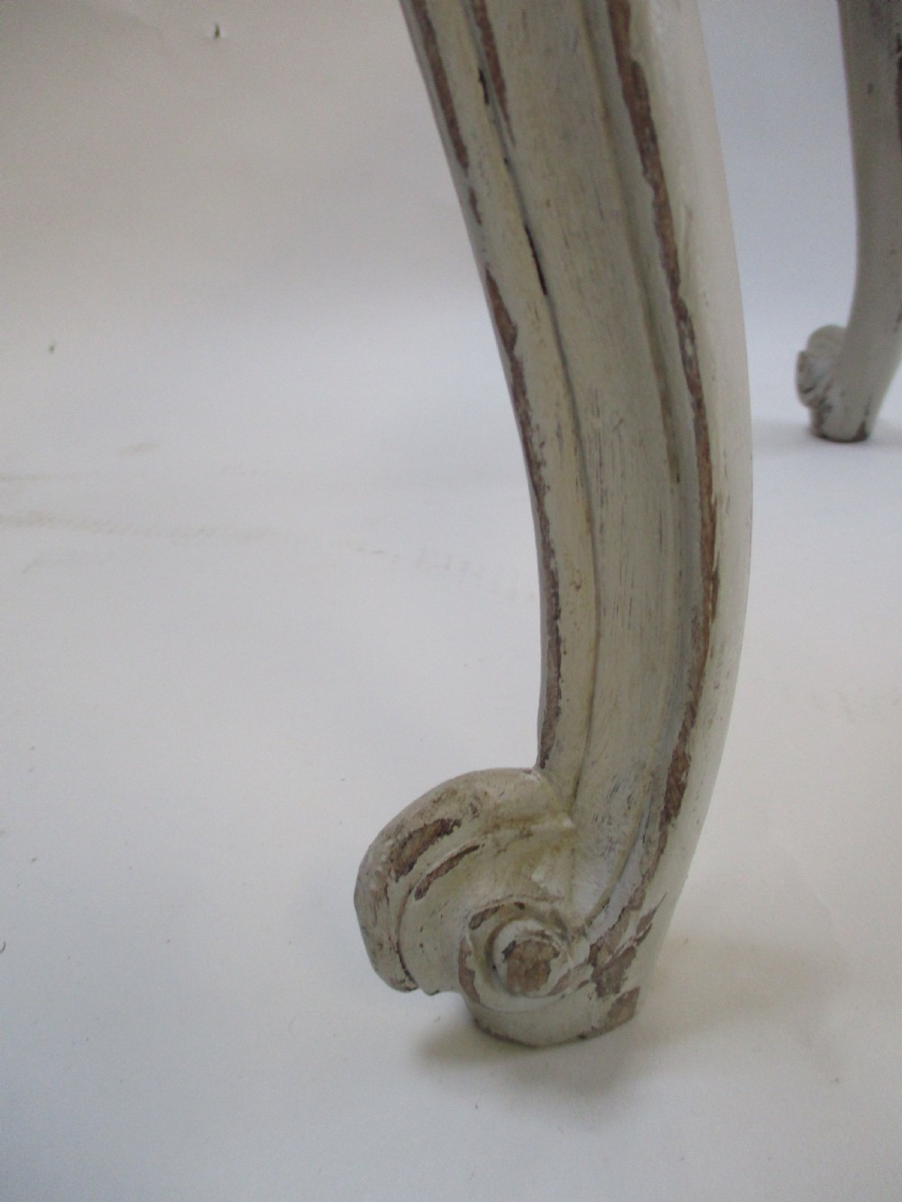 A French Louis XV style rectangular stool with hand-carved floral aprons, distressed grey cabriole legs, and a cream upholstered top. View V