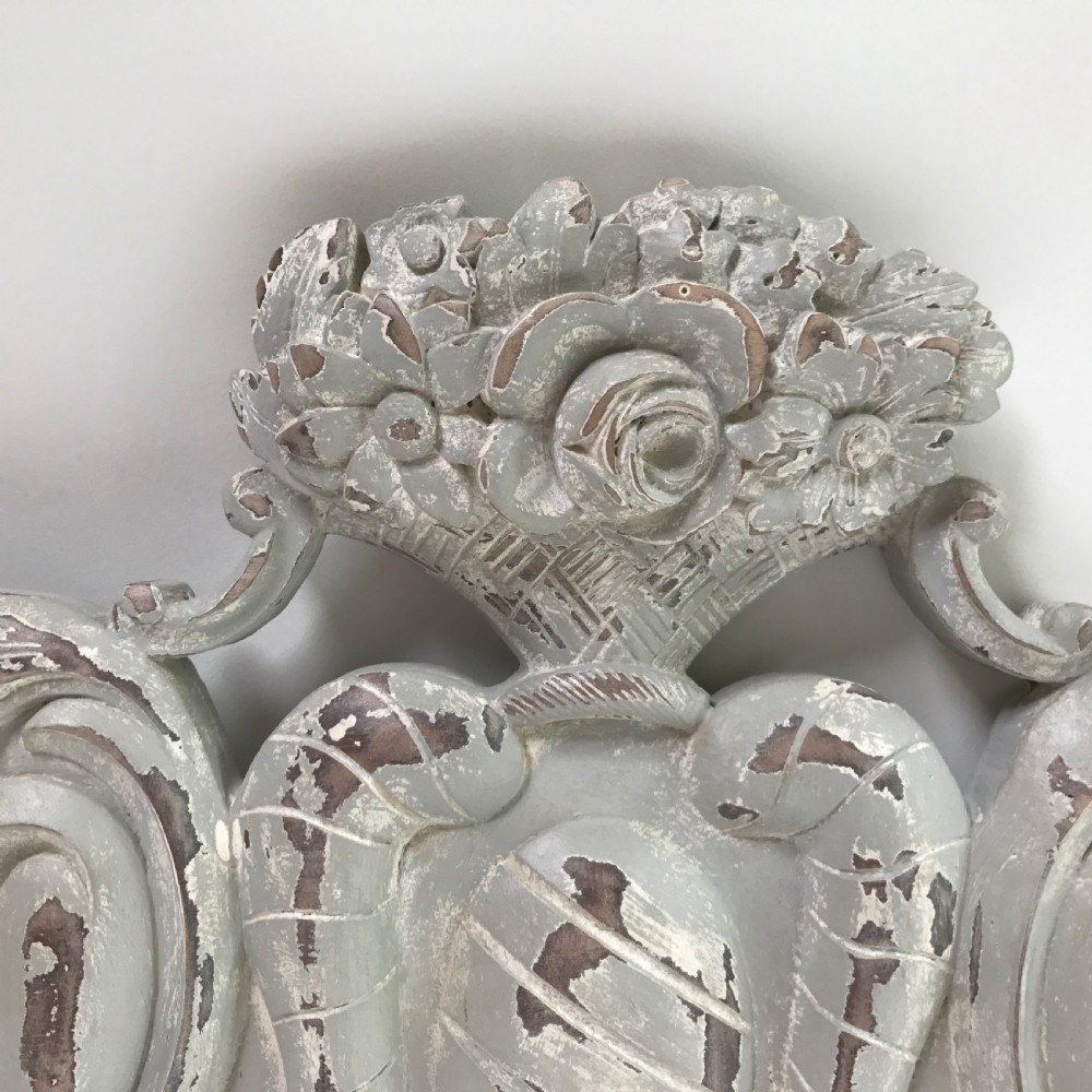 A carved wooden architectural pelmet featuring central scroll motifs and a distressed grey painted finish. View II