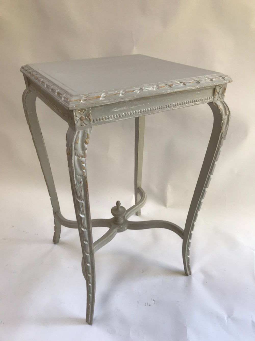A light grey painted square side table featuring carved cabriole legs, a beaded apron, and an X-shaped stretcher with a central finial.
