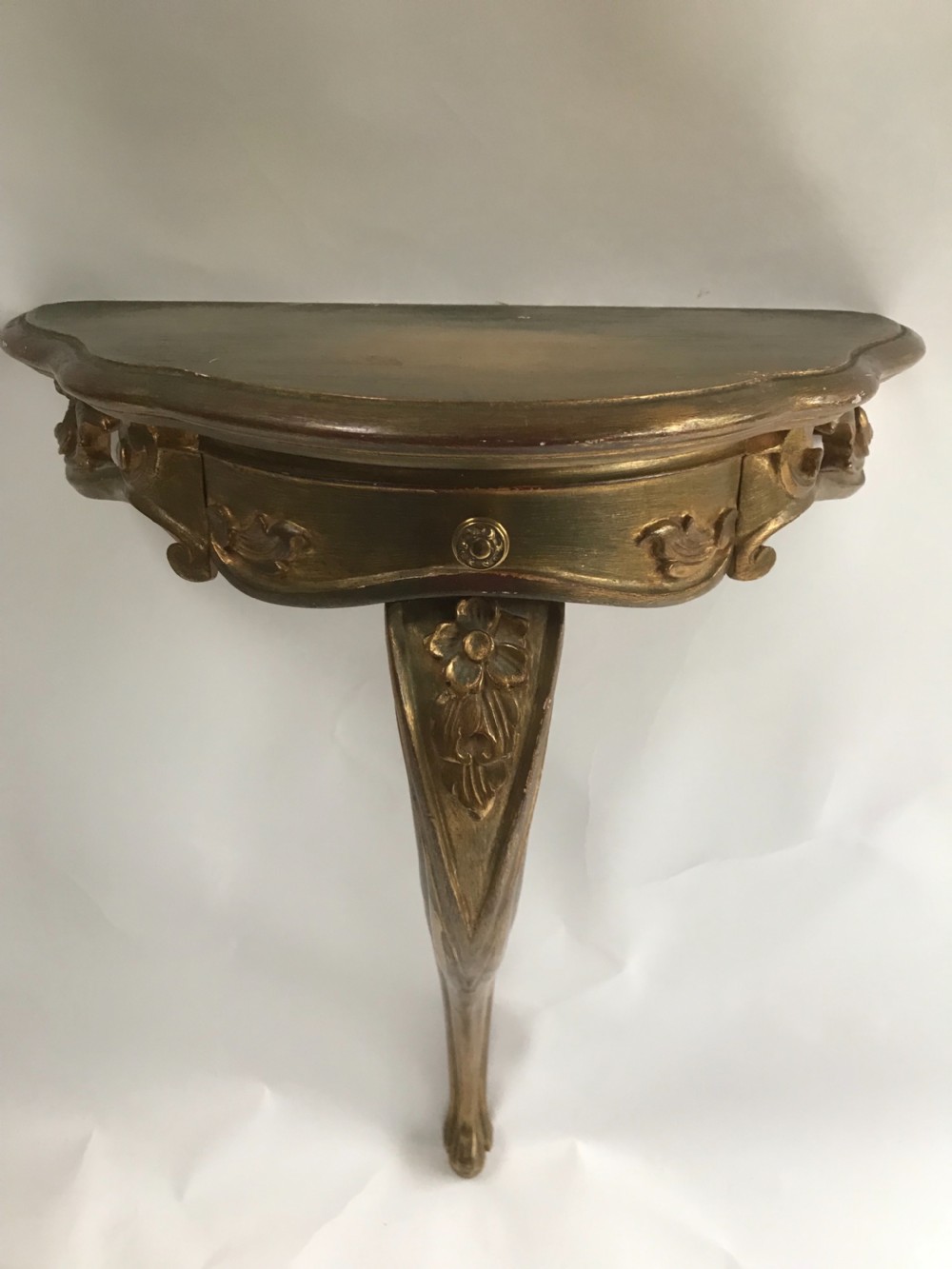 A pair of wall-mounted Italian giltwood console tables with serpentine tops, carved floral aprons, and single cabriole legs. View II