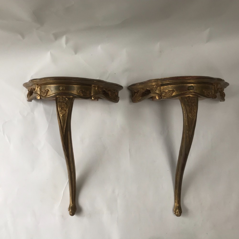 A pair of wall-mounted Italian giltwood console tables with serpentine tops, carved floral aprons, and single cabriole legs. View III
