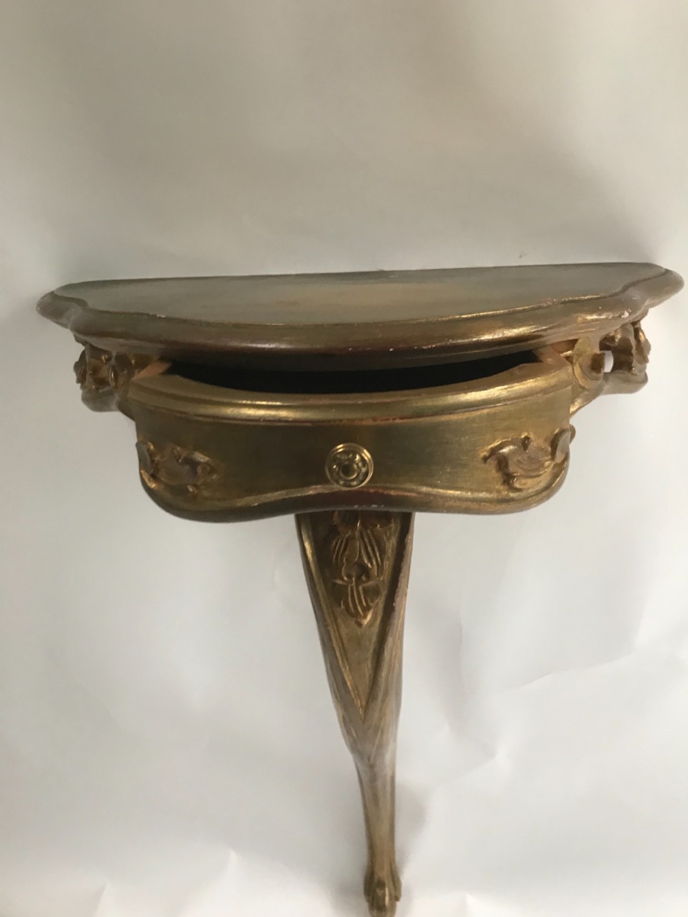 A pair of wall-mounted Italian giltwood console tables with serpentine tops, carved floral aprons, and single cabriole legs. View IV