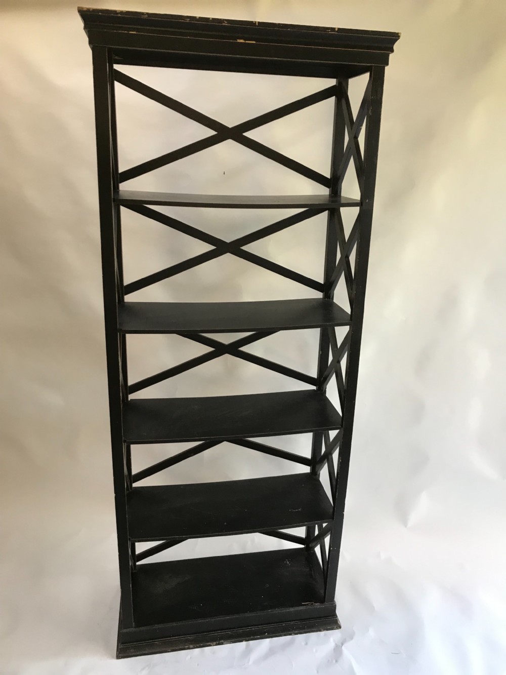 A tall, freestanding black painted open shelving unit featuring five horizontal tiers, X-frame lattice sides, a moulded top cornice, and a plinth base. View IV