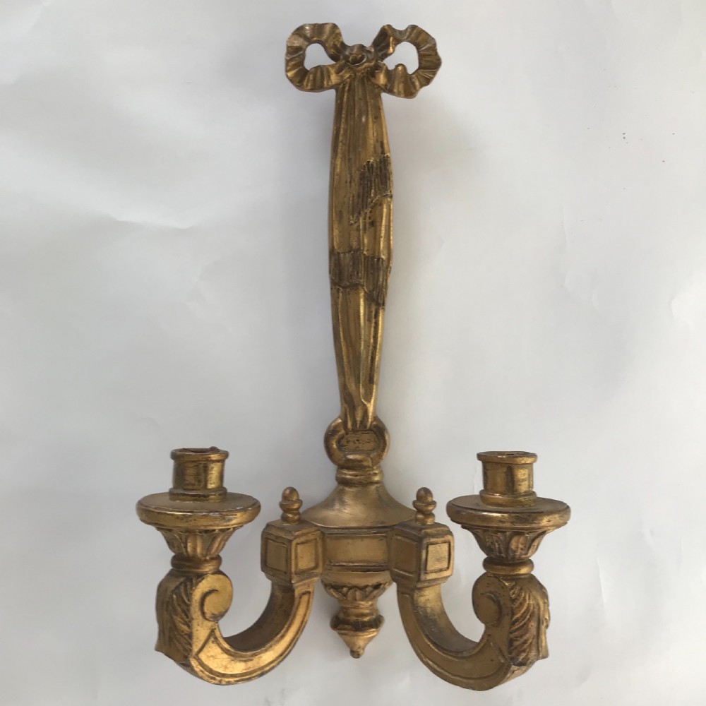 A pair of French carved giltwood wall lights featuring ribbon bow backplates and two scrolling candle arms with acanthus leaf decoration. View IV