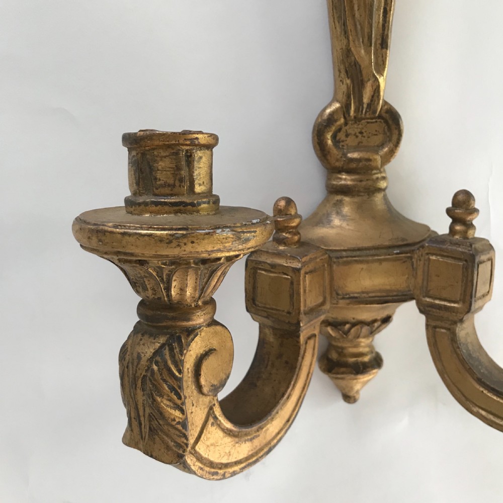 A pair of French carved giltwood wall lights featuring ribbon bow backplates and two scrolling candle arms with acanthus leaf decoration. View V