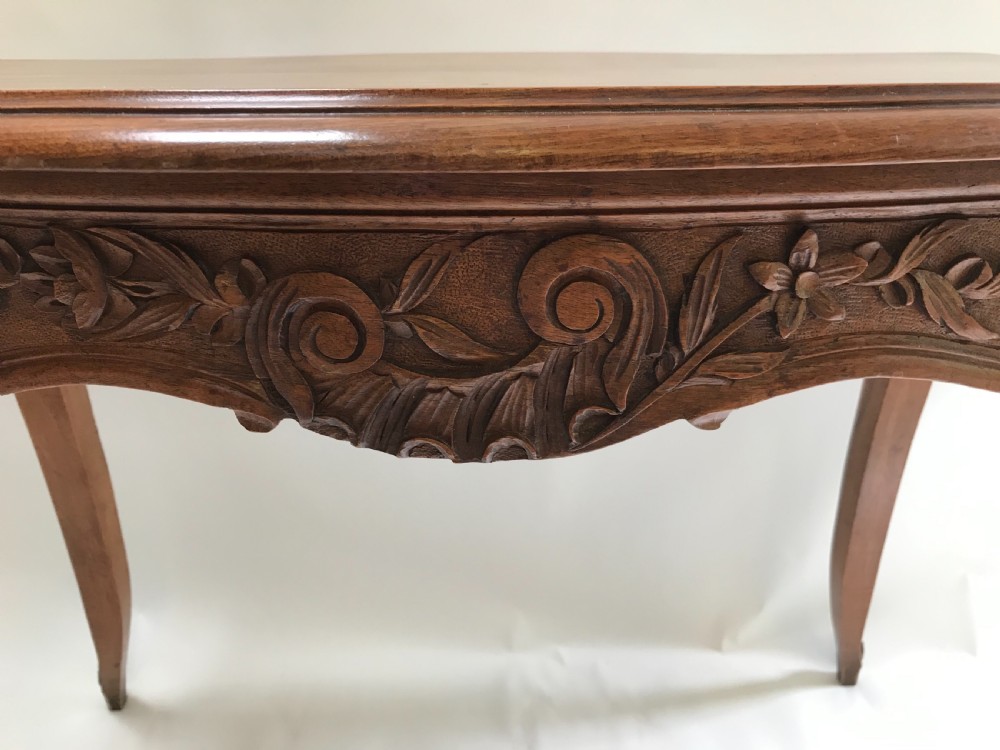 An antique French walnut centre table featuring carved floral frieze detailing and slender cabriole legs with a serpentine top. View II