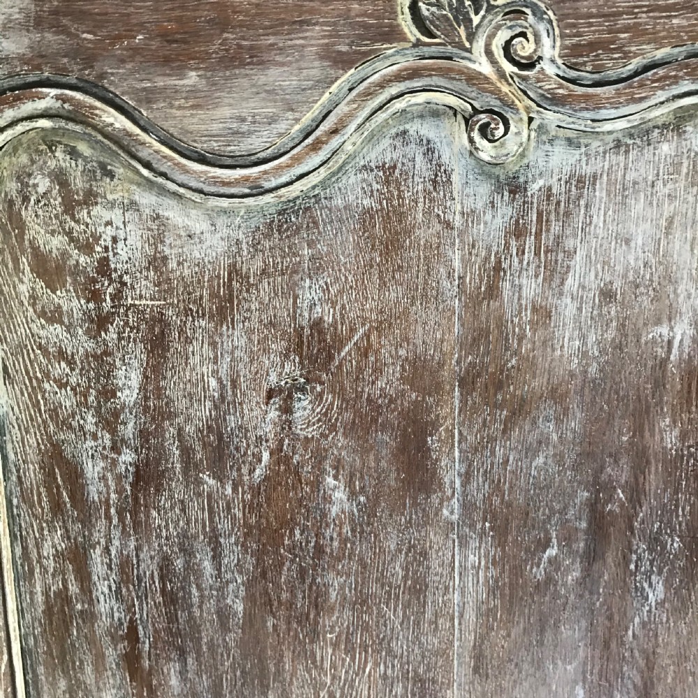 A pair of antique French carved wooden doors featuring a distressed grey painted finish, moulded serpentine panels, and original iron hinges. View V
