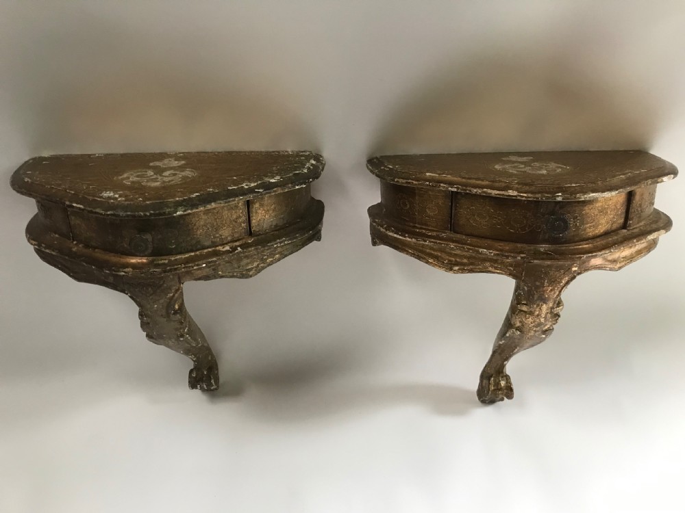 A pair of small wall-mounted Italian giltwood console tables with single carved cabriole legs and detailed aprons. View II