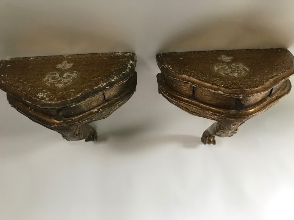 A pair of small wall-mounted Italian giltwood console tables with single carved cabriole legs and detailed aprons. View III