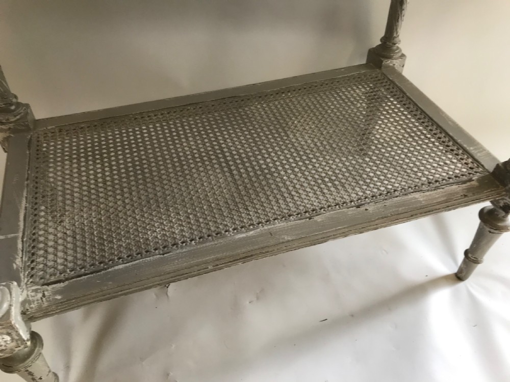 A French Neoclassical style painted wooden side table featuring a dark striated marble top, spiral turned legs, and a woven cane lower shelf. View V