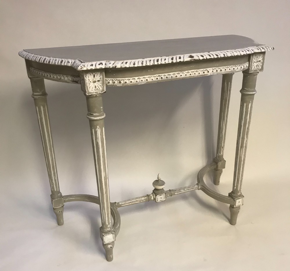A French Louis XVI style painted console table in grey and white featuring fluted legs, carved rosettes, and an arched stretcher with a central finial. View III
