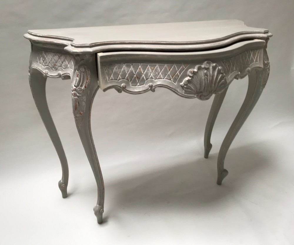 A French Louis XV style grey painted console table featuring cabriole legs, a carved shell motif on the apron, and a serpentine top. View II