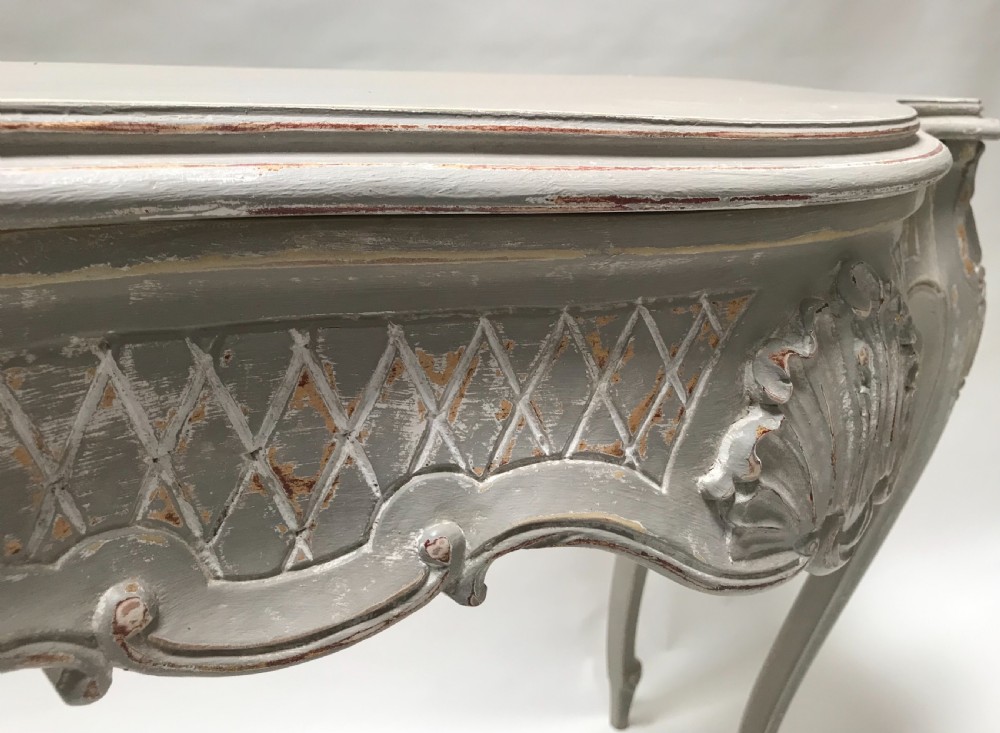 A French Louis XV style grey painted console table featuring cabriole legs, a carved shell motif on the apron, and a serpentine top. View III