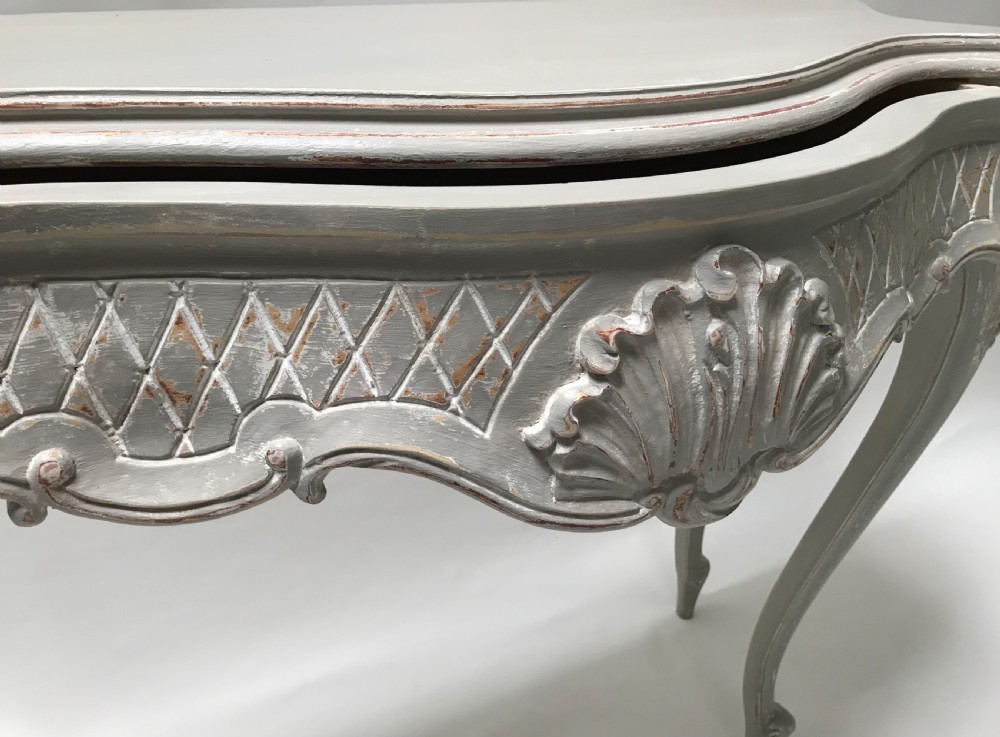 A French Louis XV style grey painted console table featuring cabriole legs, a carved shell motif on the apron, and a serpentine top. View IV