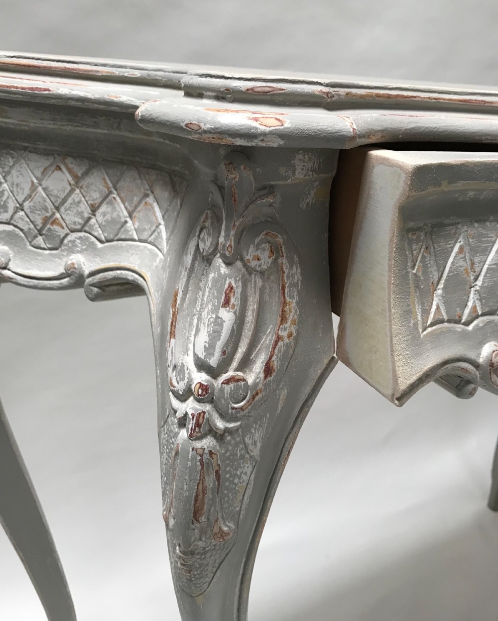 A French Louis XV style grey painted console table featuring cabriole legs, a carved shell motif on the apron, and a serpentine top. View IX