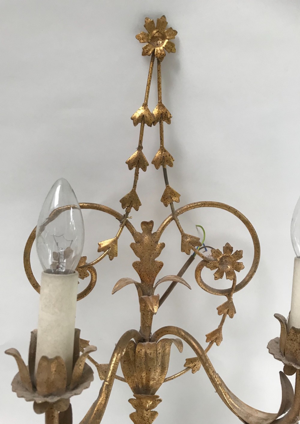 A French gilded metal five-light wall sconce decorated with scrollwork, leaf foliage, and flower-shaped candle cups. View IV