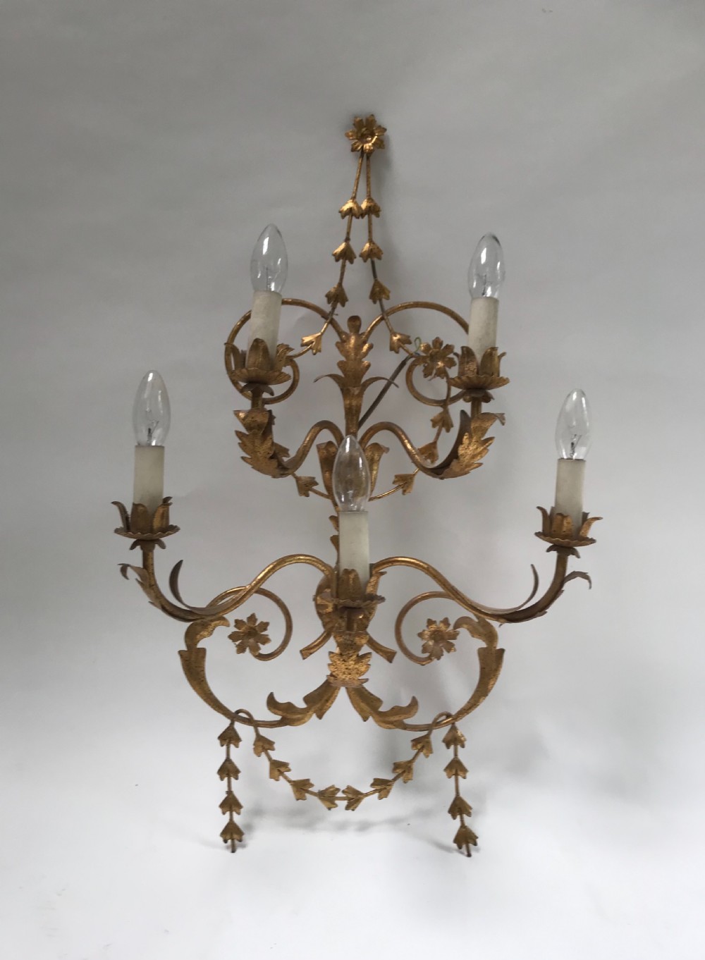 A French gilded metal five-light wall sconce decorated with scrollwork, leaf foliage, and flower-shaped candle cups. View VII