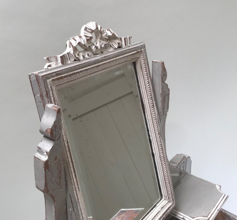 A French painted grey dressing table featuring a variegated reddish-brown marble top, an adjustable central mirror with a carved crest, two small side shelves, and tapered fluted legs. View III