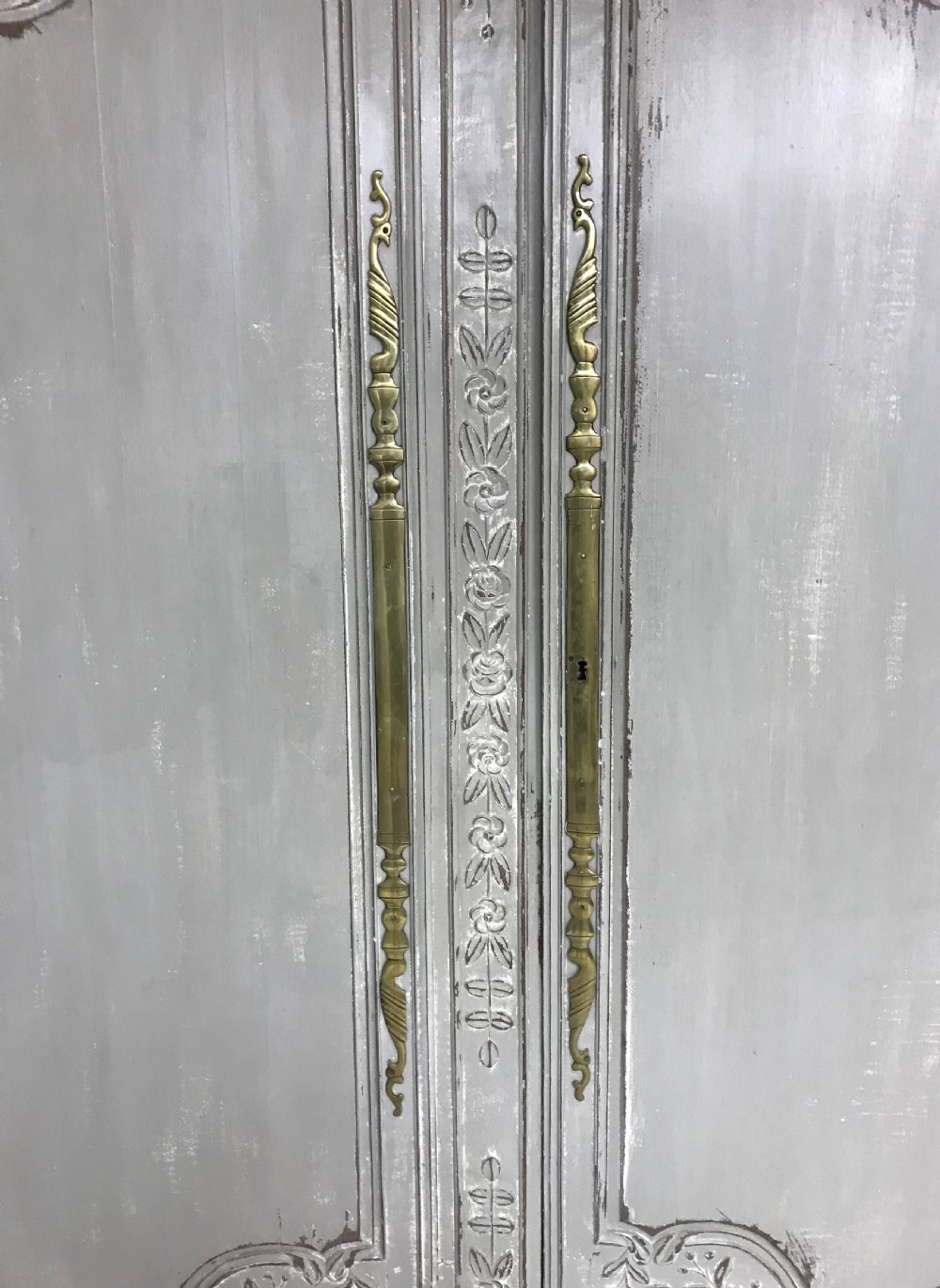 A pair of grey painted antique French doors featuring hand-carved floral panels and long brass handles. View III