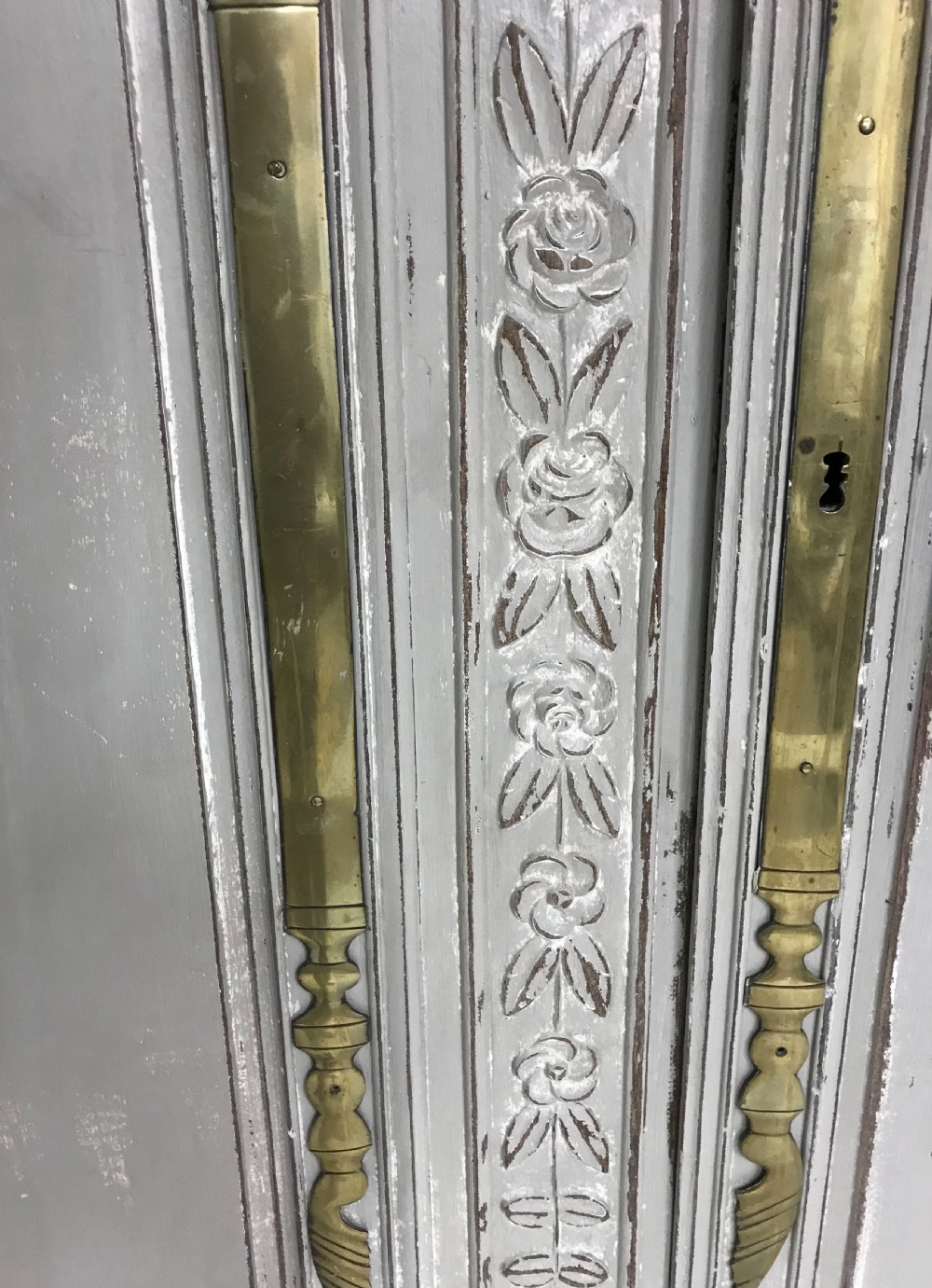 A pair of grey painted antique French doors featuring hand-carved floral panels and long brass handles. View IV