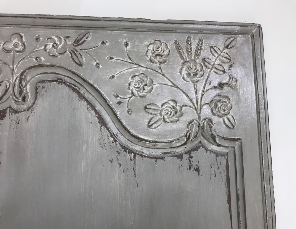 A pair of grey painted antique French doors featuring hand-carved floral panels and long brass handles. View V