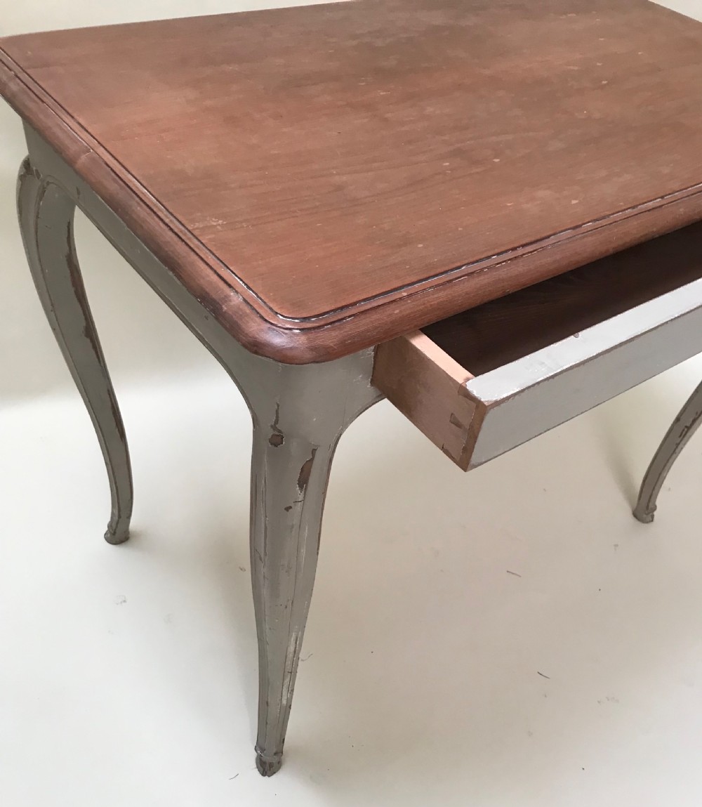 A French provincial style table featuring a natural walnut wood top, a grey painted base with cabriole legs, and a single drawer. View III