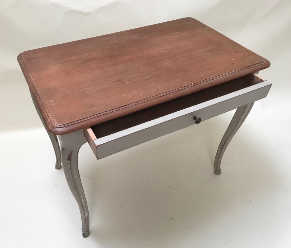 A French provincial style table featuring a natural walnut wood top, a grey painted base with cabriole legs, and a single drawer. View V