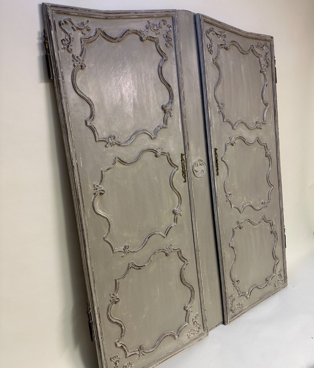 A pair of grey painted French timber doors featuring hand-carved Rococo style panel mouldings and metal hardware. View IV