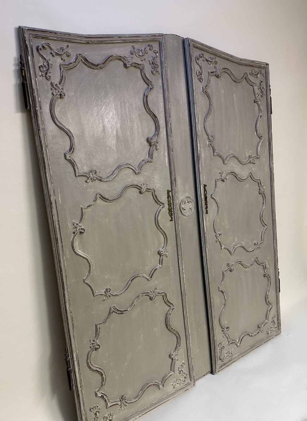 A pair of grey painted French timber doors featuring hand-carved Rococo style panel mouldings and metal hardware. View V