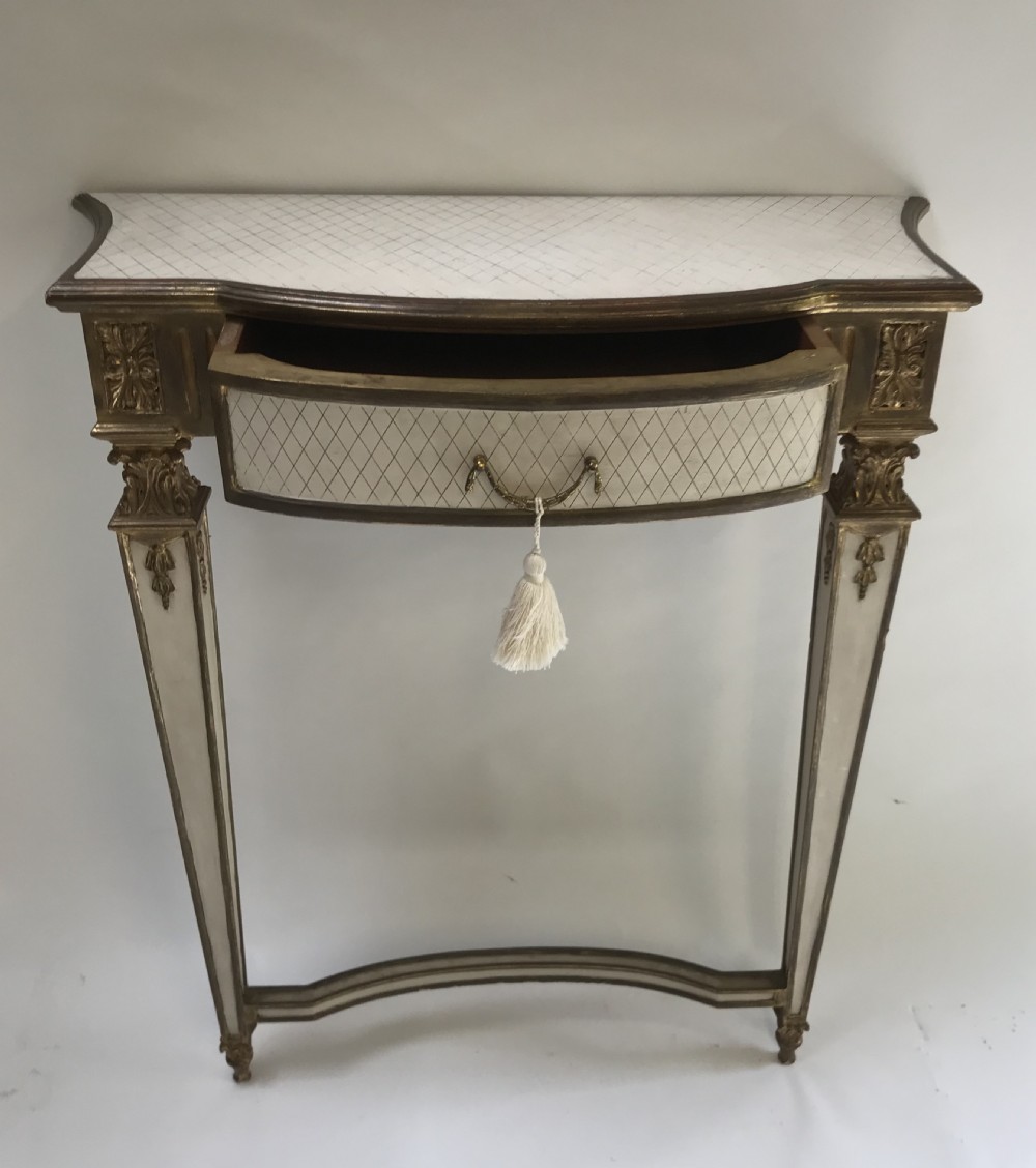 A French Neoclassical style console table with a cream diamond-patterned top, central drawer with a tassel pull, and gilded tapered legs. View II