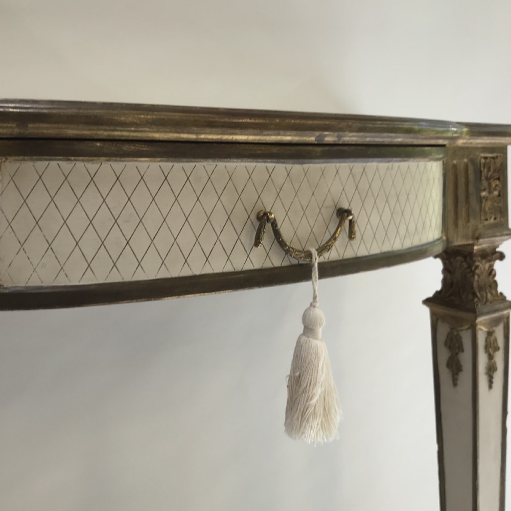A French Neoclassical style console table with a cream diamond-patterned top, central drawer with a tassel pull, and gilded tapered legs. View IV