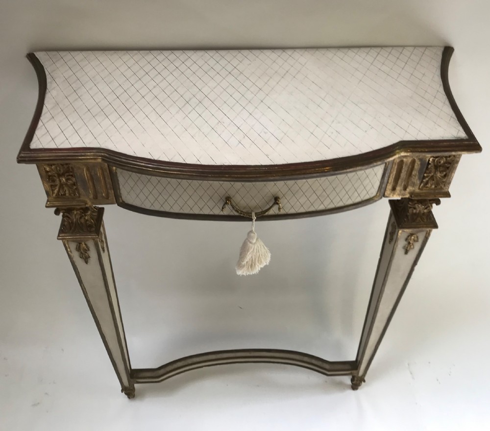A French Neoclassical style console table with a cream diamond-patterned top, central drawer with a tassel pull, and gilded tapered legs. View VII