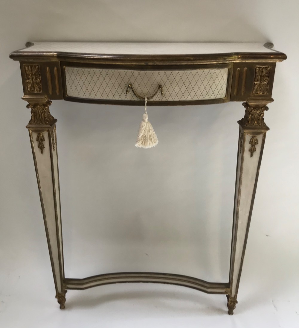 A French Neoclassical style console table with a cream diamond-patterned top, central drawer with a tassel pull, and gilded tapered legs. View VIII