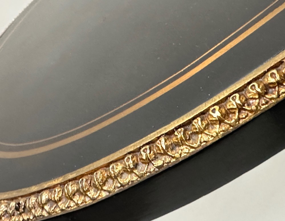 An ebonised Napoleon III drop-leaf table featuring gilt brass mounts, incised inlay, and turned legs joined by a curved stretcher. View VI