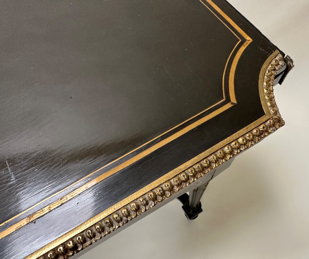 An ebonised Napoleon III drop-leaf table featuring gilt brass mounts, incised inlay, and turned legs joined by a curved stretcher. View VIII
