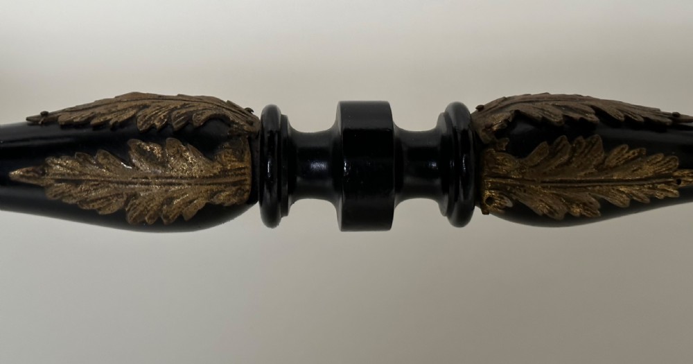 An ebonised Napoleon III drop-leaf table featuring gilt brass mounts, incised inlay, and turned legs joined by a curved stretcher. View IX