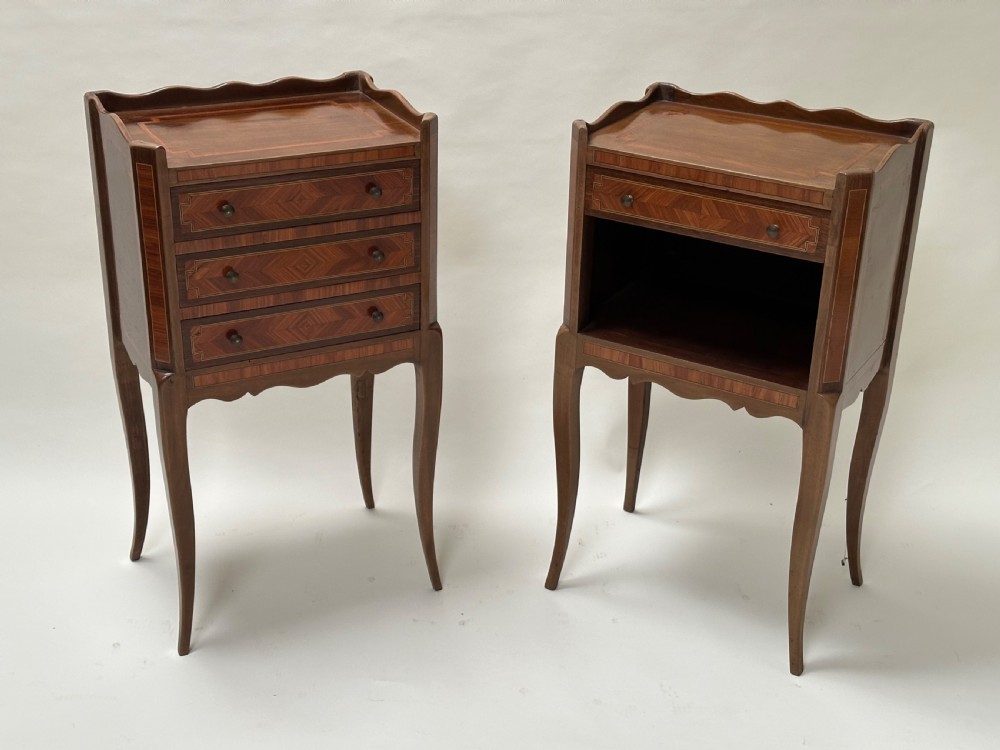 A pair of French Louis XV style warm brown walnut bedside tables featuring geometric parquetry inlay, shaped galleries, and slender cabriole legs.
